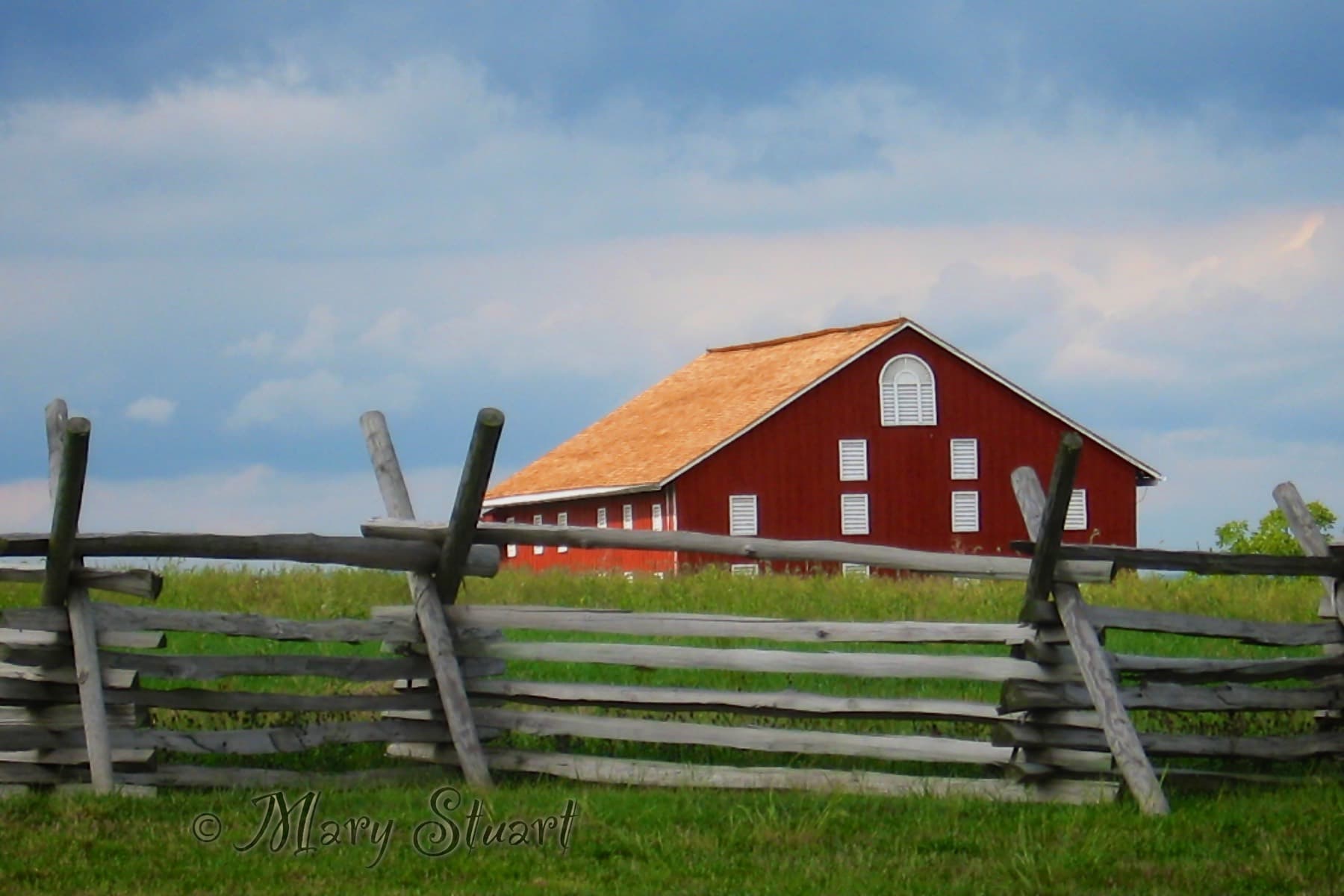 A red farm building in a green landscape
